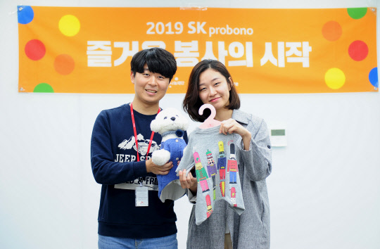 SK건설 임직원들이 직접 만든 반려동물용 겨울옷을 들고 기념촬영을 하고 있다. <SK건설 제공>